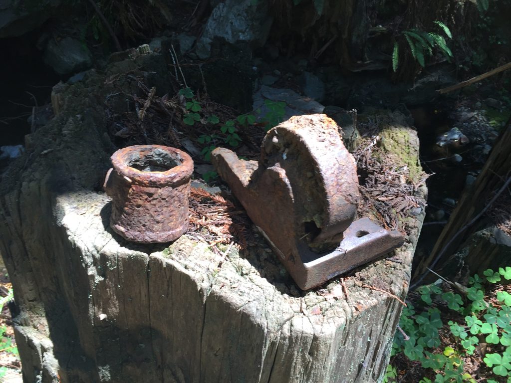 Close view of the arrastra's iron drive hardware — a rusted bearing block and collar recovered at the Plaskett Creek site.