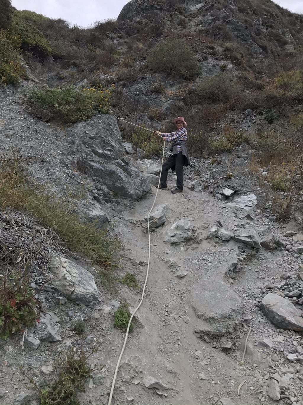 Kim Alderson on the rope-assisted scramble down the serpentine cliff into Jade Cove — rockhounds have kept this route open for generations.