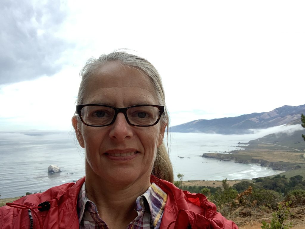 Kim Alderson on the Plaskett Ridge trail, the coast her husband's family settled spread out behind her.