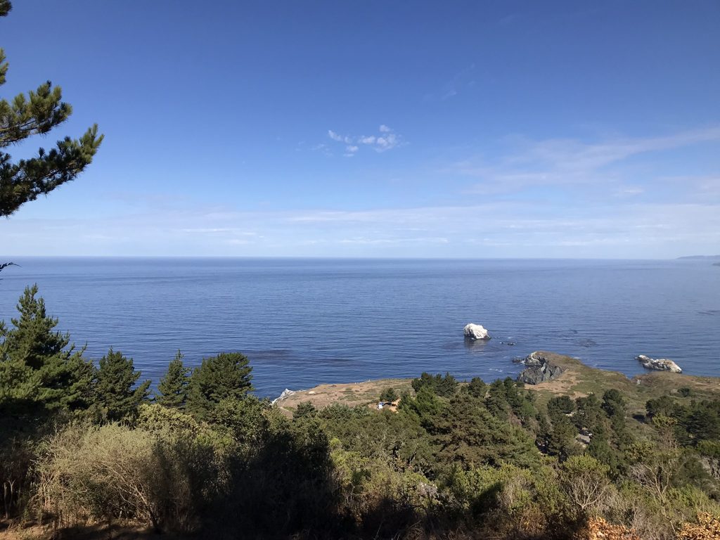 From high on Plaskett Ridge, Plaskett Rock rides the blue water off the point.