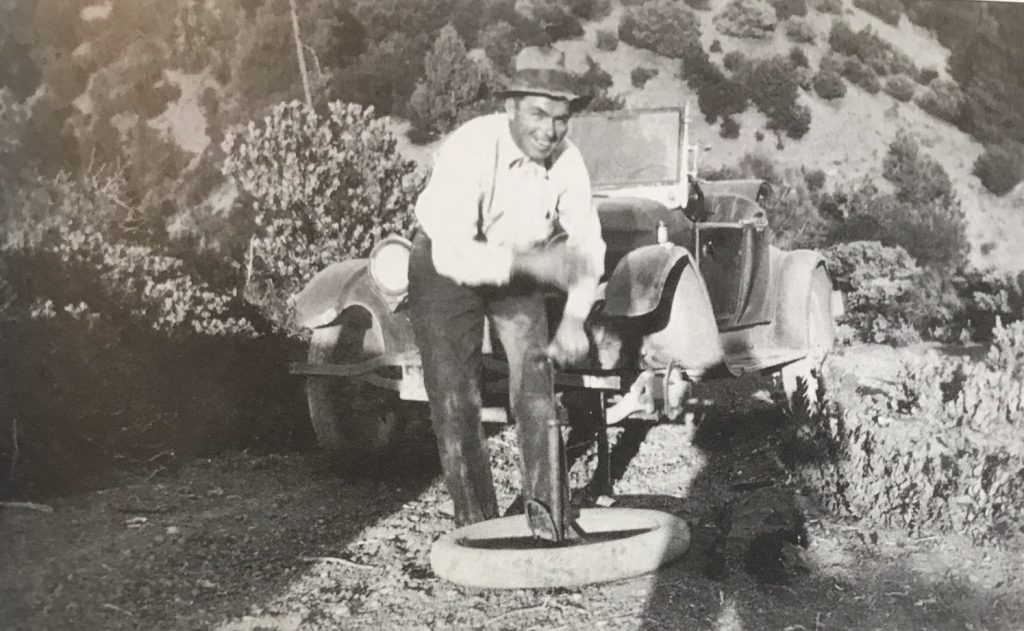 Charlie Krenkel changing a tire c. 1930